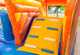 Opblaasbaar overdekt springkasteel in thema piraat met een glijbaan op het springvlak, klimtoren en leuke obstakels voor kids. Koop springkastelen online bij JB Inflatables Nederland