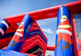 Opblaasbaar overdekt springkasteel in thema brandweer met een glijbaan op het springvlak, klimtoren en leuke obstakels voor kids. Koop springkastelen online bij JB Inflatables Nederland