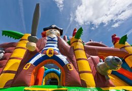 Koop mini opblaasbare multiplay springkussen in piratenboot thema met glijbaan voor kinderen. Bestel opblaasbare springkussens online bij JB Inflatables Nederland