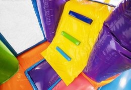 Opblaasbaar springkussen met glijbaan in hippie thema met veel kleuren te koop voor kinderen