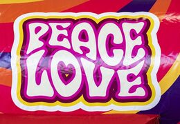 Opblaasbaar luchtkussen met glijbaan in hippy thema met veel kleuren kopen 