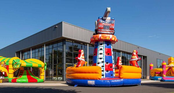 Buitenzijde van industrieel pand van JB Inflatables met kussens ervoor